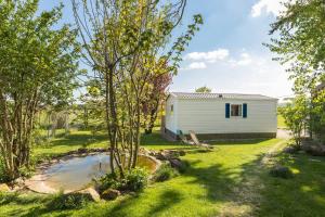 a white shed in a yard with trees at Tonis Hütte in Hohenfels