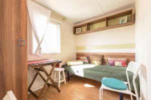 a small bedroom with a bed and a desk at Tonis Hütte in Hohenfels