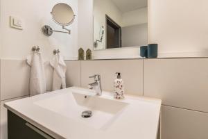 a white bathroom with a sink and a mirror at Zum Krähenholz Wohnung 9 in Husby
