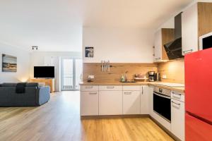 a kitchen with white cabinets and a red refrigerator at Zum Krähenholz Wohnung 9 in Husby