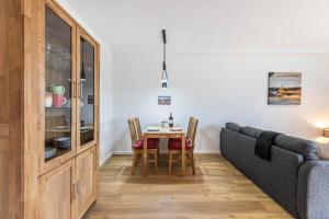 a living room with a table and a couch at Zum Krähenholz Wohnung 9 in Husby +7 photos