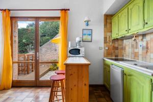 a kitchen with green cabinets and a counter with a microwave at Bastidon Avec Terrasse Vue Mer in Carqueiranne