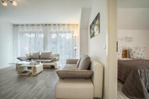 a bedroom with a bed and a living room at Familien-Apartment 1 in Meersburg
