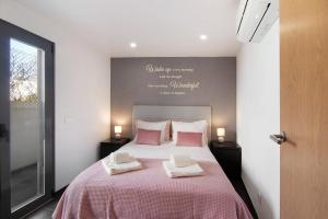 a bedroom with a bed with two towels on it at Be Glow Home in Alvor