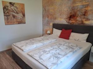 a bed in a bedroom with a painting on the wall at Tobel Lounge in Sigmarszell