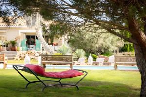 a chair sitting in the grass under a tree at Lointaines escapades in Perpignan