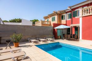 a swimming pool with chairs and a house at Villa Malena in Llucmajor