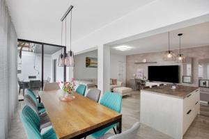 a dining room and living room with a table and chairs at Villa La Blanca in Arona