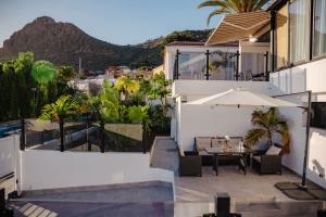 a patio with a table and an umbrella on a building at Villa La Blanca in Arona