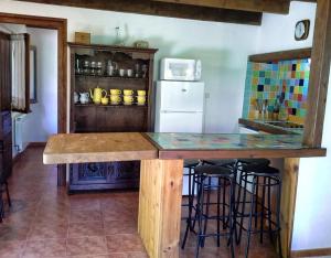 a kitchen with a counter with stools and a refrigerator at Apartamento Rural Rubó in Alles