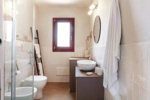 a bathroom with a toilet and a sink and a mirror at La casa di Debora in San Teodoro