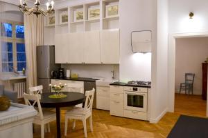 une cuisine avec des placards blancs et une table avec des chaises dans l'établissement Exclusive Old Town Apartment by Renters, à Wrocław