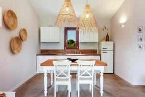 a kitchen with a wooden table and white cabinets at La casa di Debora in San Teodoro +17 photos