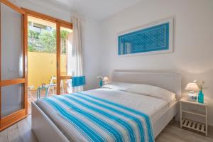 a white bed in a bedroom with a window at Relax Space in Cascabraga
