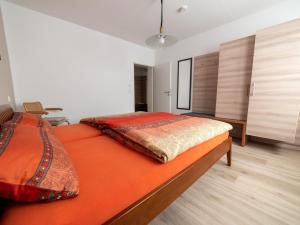a bedroom with a large bed with an orange mattress at Ferienwohnung Pusteblume in Kappelrodeck