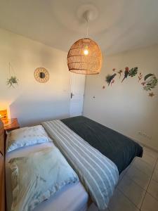 a bedroom with a bed and a pendant light at La Villa Yenna in Vergèze +7 photos