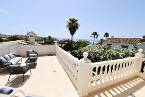 a balcony with a white railing and chairs at Villa with separate apartment in Mijas Costa