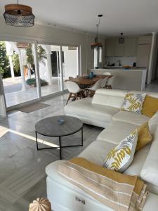 a living room with white furniture and a table at Villa with separate apartment in Mijas Costa