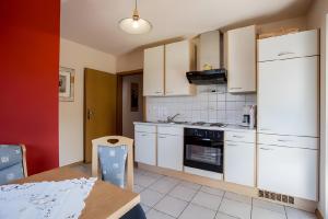 a kitchen with white cabinets and a table and a table sidx sidx at Ferienwohnung Echle in Oberharmersbach