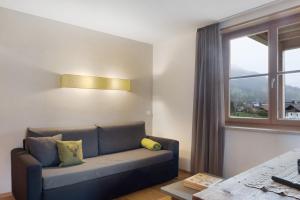 a living room with a couch and a window at Angerle Alm Apt Similde B in Carezza al Lago