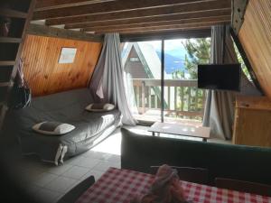 a living room with a couch and a large window at Chalet Les Angles in Les Angles
