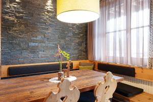 a dining room with a wooden table and chairs at Angerle Alm Apt Similde B in Carezza al Lago