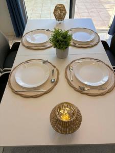 a table with four plates and a basket on it at La Villa Yenna in Vergèze
