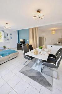 a white living room with a table and chairs at La Villa Yenna in Vergèze