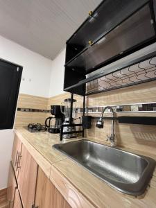 a kitchen with a sink and a microwave at 306ApartaesudioRomance in Arauca +11 photos