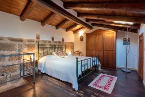ein Schlafzimmer mit einem Bett in einem Zimmer mit Holzdecke in der Unterkunft Alghero Old Town Charm - Sardinia in Alghero