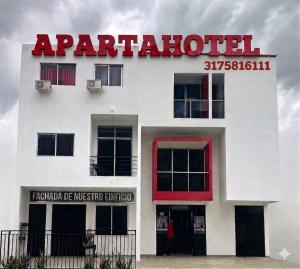 a white building with a red sign on it at 306ApartaesudioRomance in Arauca