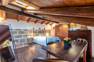 ein Schlafzimmer mit einem Bett und einem Tisch in einem Zimmer in der Unterkunft Alghero Old Town Charm - Sardinia in Alghero + 28 Fotos