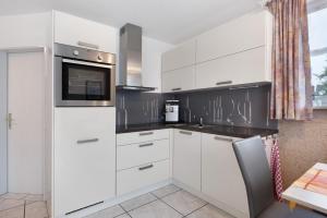a kitchen with white cabinets and a microwave at Preiser in Moos