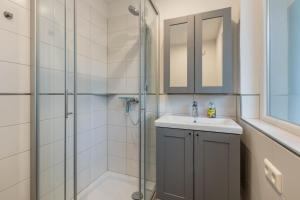 a bathroom with a shower and a sink and a mirror at Ferienhaus Rosswangen in Balingen +44 photos