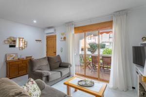 a living room with a couch and a television at Casa Pedro Piscina in Puerto Marino