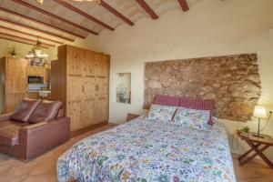 a bedroom with a bed and a stone wall at Loft Rural Orenetes ideal parejas in Sant Jaume dels Domenys