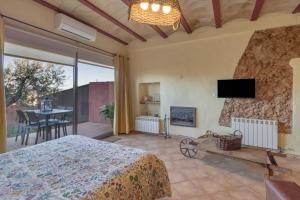 a bedroom with a bed and a tv on a wall at Loft Rural Orenetes ideal parejas in Sant Jaume dels Domenys