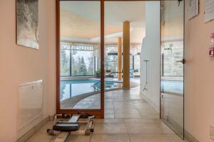 a house with a swimming pool and a large mirror at Sabina Dolomites Latsche in Alpe di Siusi