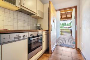 a kitchen with a stove and a door to a patio at Sabina Dolomites Latsche in Alpe di Siusi
