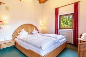 a bedroom with a wooden bed and a window at Sabina Dolomites Latsche in Alpe di Siusi +16 photos