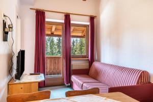 a living room with a couch and a window at Sabina Dolomites Latsche in Alpe di Siusi