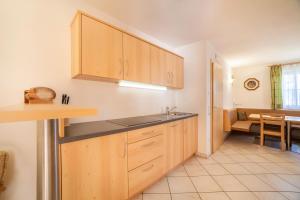 a kitchen with wooden cabinets and a sink in it at Parigger Apt Zirbe in Racines +25 photos