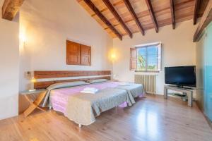 a bedroom with two beds and a flat screen tv at Can Rito in Islas Baleares