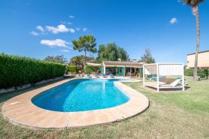 a swimming pool in a yard next to a house at Can Rito in Islas Baleares