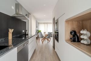a kitchen with black and white counters and a dining room at Felicidade in Mondim de Basto