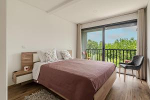 a bedroom with a bed and a balcony at Felicidade in Mondim de Basto +17 photos
