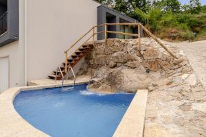 a swimming pool with a stairs next to a building at Felicidade in Mondim de Basto