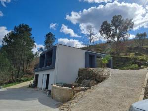 a house on a hill with a stone wall at Felicidade in Mondim de Basto