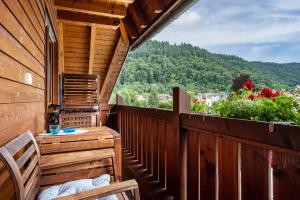 a balcony of a cabin with a bench and flowers at Haus Grünblick in Münstertal