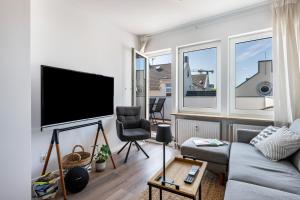 a living room with a couch and a flat screen tv at Ferienwohnung mit Dachterrasse in Heide